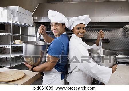 Stock Photo - Multi-ethnic pastry chefs mixing batter back to back. Fotosearch