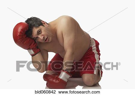 Stock Image - Overweight boxer kneeling on floor. Fotosearch