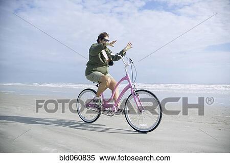 Senior woman riding bicycle on beach View Large Photo Image Stock Photography - Senior woman riding bicycle on beach. Fotosearch
