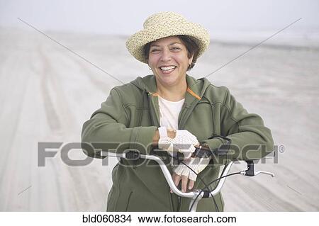 Senior woman with bicycle on beach View Large Photo Image Picture - Senior woman with bicycle on beach. Fotosearch
