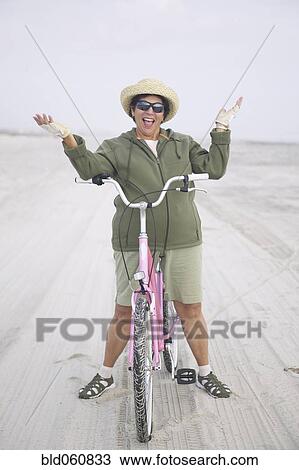 Senior woman with bicycle on beach View Large Photo Image Stock Image - Senior woman with bicycle on beach. Fotosearch