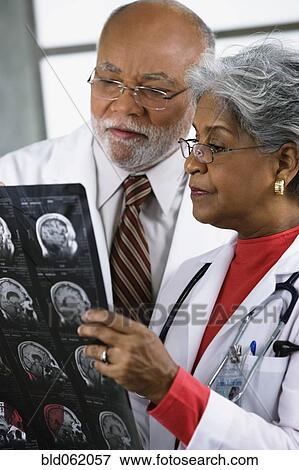 Two African doctors examining x-rays View Large Photo Image Stock Photo - Two African doctors examining x-rays. Fotosearch