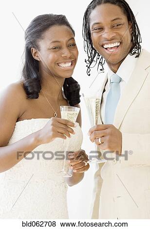African bride and groom holding champagne flutes View Large Photo Image Stock Photo - African bride and groom holding champagne flutes. Fotosearch