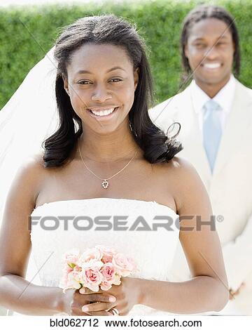Stock Image - African bride holding bouquet. Fotosearch