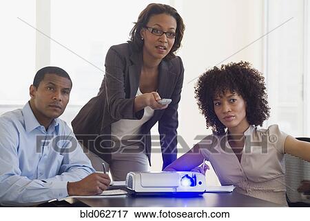 Stock Photo - African business people watching slideshow. Fotosearch