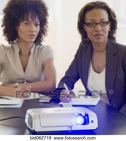 Stock Photo - African business people watching slideshow. Fotosearch