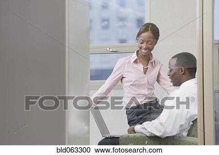 Stock Image - African business people working on laptop in office. Fotosearch