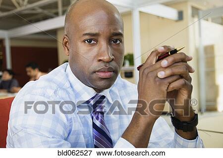 Stock Photo - African businessman looking serious in office. Fotosearch