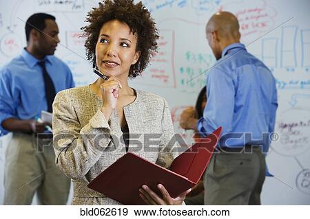 Stock Photo - African businesswoman brainstorming with co-workers. Fotosearch