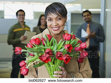 African businesswoman holding bouquet of flowers View Large Photo Image Stock Photo - African businesswoman holding bouquet of flowers. Fotosearch