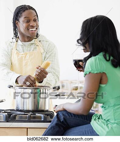 Stock Image - African couple cooking in kitchen. Fotosearch