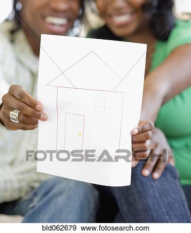 African couple holding drawing of house View Large Photo Image Stock Photo - African couple holding drawing of house. Fotosearch