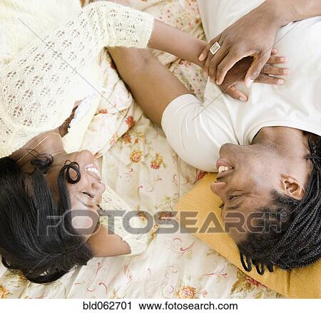 Stock Image - African couple laying in bed. Fotosearch