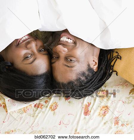 African couple laying under sheet in bed View Large Photo Image Stock Image - African couple laying under sheet in bed. Fotosearch