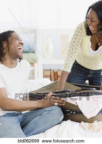Stock Photo - African couple packing suitcase. Fotosearch