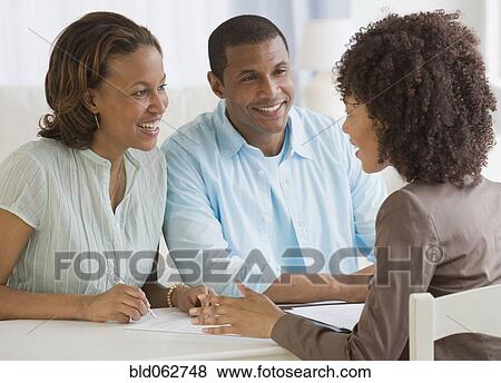 Stock Photo - African couple receiving financial consultation. Fotosearch