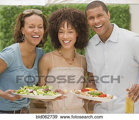 Stock Photo - African man and women at cookout. Fotosearch