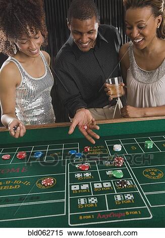African man and women playing craps at casino View Large Photo Image Stock Photography - African man and women playing craps at casino. Fotosearch