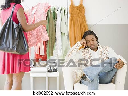 African man bored while woman shops View Large Photo Image Stock Image - African man bored while woman shops. Fotosearch