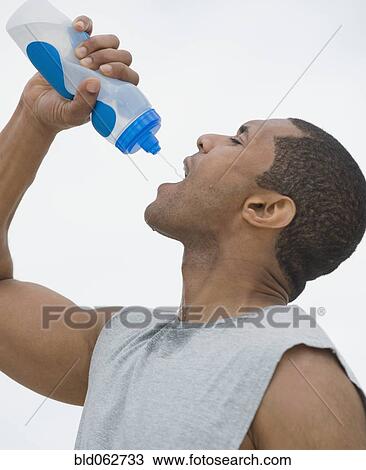 African man drinking from water bottle View Large Photo Image Stock Image - African man drinking from water bottle. Fotosearch