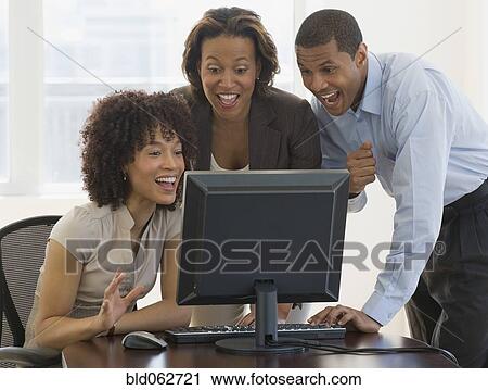 Stock Image - African people looking excited working on computer. Fotosearch