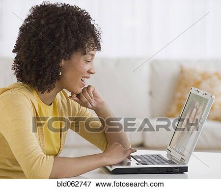 Stock Photo - African woman looking at laptop. Fotosearch