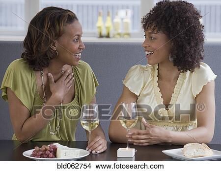 Picture - African women dining at restaurant. Fotosearch