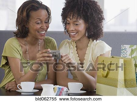 Stock Photography - African women looking at camera in restaurant. Fotosearch