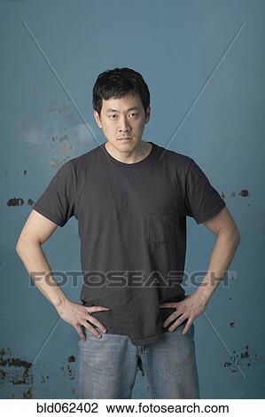 Stock Image - Angry Korean man with hands on hips. Fotosearch