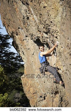 Stock Image - Argentinean man rock climbing. Fotosearch