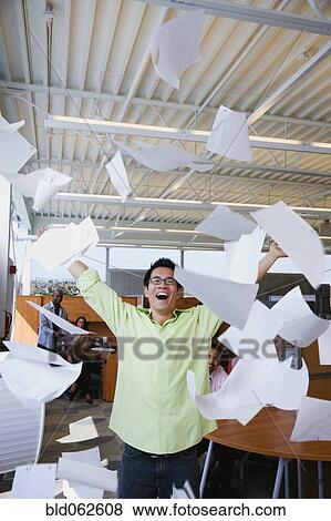 Stock Photo - Asian American businessman throwing papers in air. Fotosearch