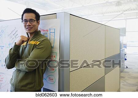 Asian businessman standing in office corridor View Large Photo Image Stock Image - Asian businessman standing in office corridor. Fotosearch