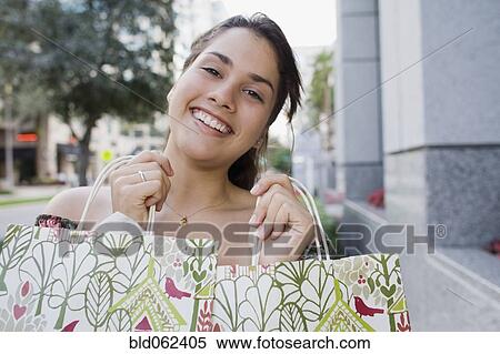 Stock Photography - Brazilian teenager holding shopping bags. Fotosearch