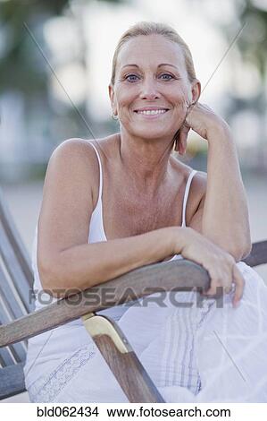 Picture - Brazilian woman sitting in lounge chair. Fotosearch
