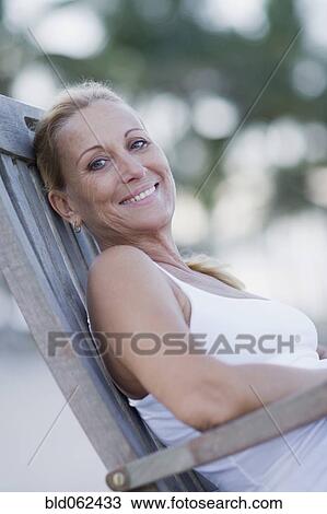 Stock Image - Brazilian woman sitting in lounge chair. Fotosearch