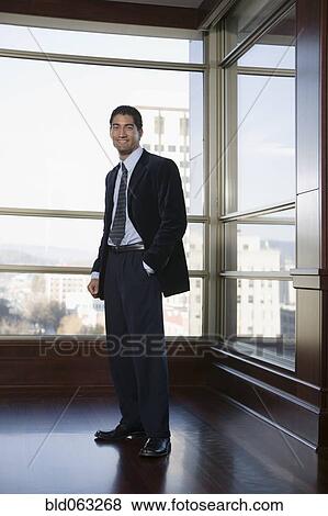 Stock Photo - Businessman smiling in corridor. Fotosearch