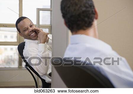 Stock Image - Businessmen exchanging gossip. Fotosearch
