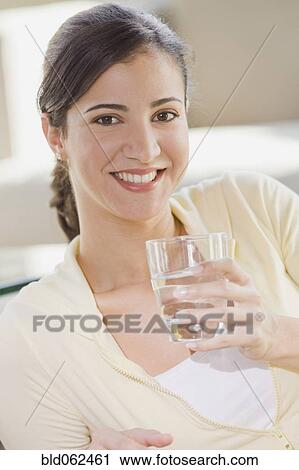 Stock Image - Close up of Cuban woman holding water glass. Fotosearch
