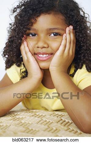 Close up of mixed race girl with head in hands View Large Photo Image Stock Photo - Close up of mixed race girl with head in hands. Fotosearch