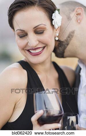 Stock Image - Cuban man kissing Cuban woman's neck. Fotosearch