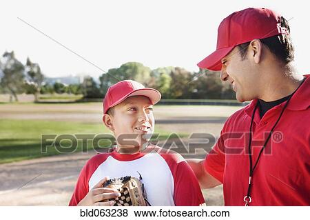 Stock Photo - Hispanic baseball player and coach talking. Fotosearch