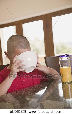 Hispanic boy drinking milk from cereal bowl View Large Photo Image Stock Photo - Hispanic boy drinking milk from cereal bowl. Fotosearch