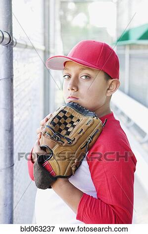 Stock Photo - Hispanic boy in baseball uniform holding baseball glove. Fotosearch