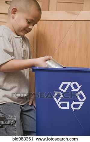 Stock Image - Hispanic boy recycling tin can. Fotosearch