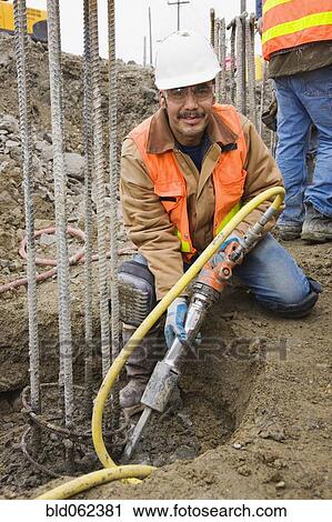 Hispanic construction worker holding equipment View Large Photo Image Stock Image - Hispanic construction worker holding equipment. Fotosearch
