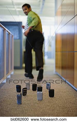Indian businessman running from cell phones on office floor View Large Photo Image Stock Image - Indian businessman running from cell phones on office floor. Fotosearch