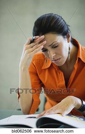 Stock Photograph - Latin American businesswoman concentrating on reading. Fotosearch