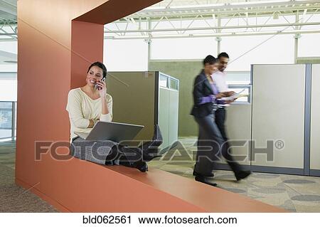Latin American businesswoman with laptop talking on cell phone in office View Large Photo Image Stock Image - Latin American businesswoman with laptop talking on cell phone in office. Fotosearch