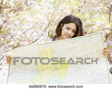 Stock Image - Middle Eastern woman holding map. Fotosearch