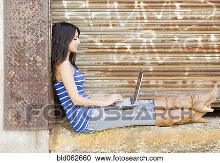 Stock Image - Middle Eastern woman typing on laptop. Fotosearch